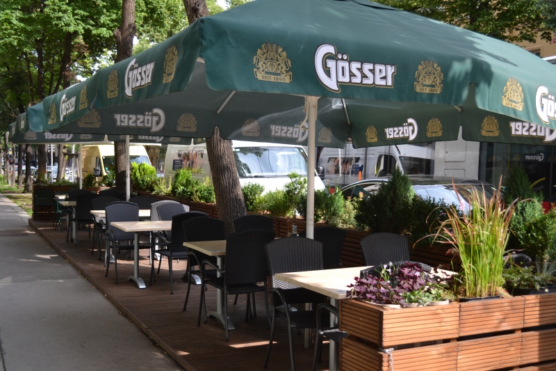 Der echte Schanigarten des Gasthaus Genuss mit schattigen Sitzplätzen und Pflanzen